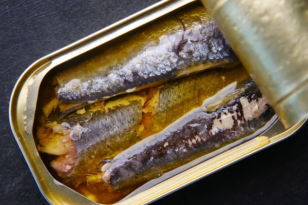 Beyaz karolar üzerinde sardalya konservesini aç.