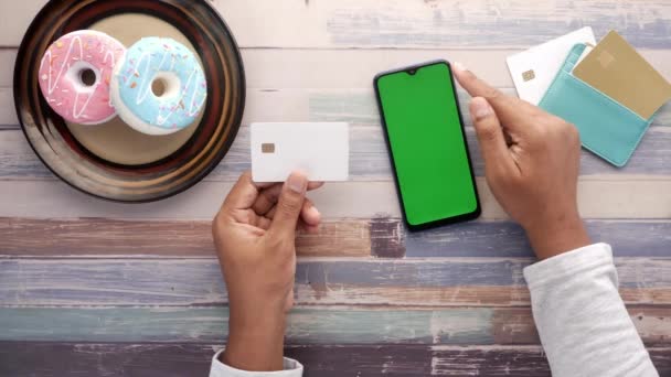 Vista superior de mão segurando cartão de crédito e usando telefone inteligente compras on-line — Vídeo de Stock