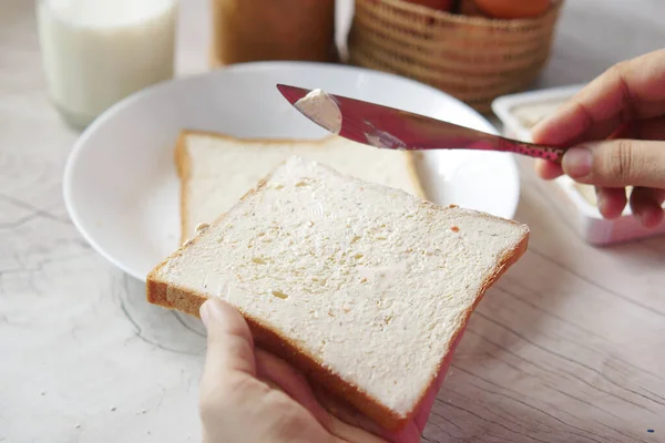 Smör som sprids på ett bröd på nära håll — Stockfoto