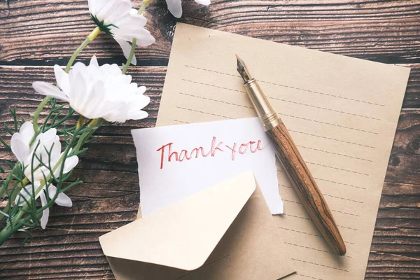 Mensagem de agradecimento e envelope na mesa de madeira — Fotografia de Stock