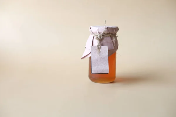Świeży miód w szklanym słoiku z papierową etykietą — Zdjęcie stockowe