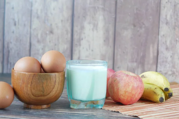 Uova in un inchino e un bicchiere di latte sul tavolo — Foto Stock