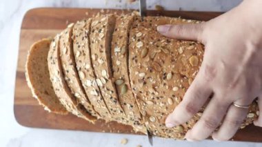 Kadınlar masada pişmiş kaş ekmeğini elleriyle kesiyorlar..