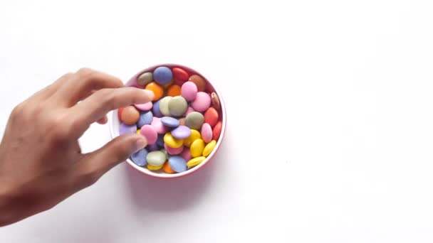 Niño niño recogiendo caramelos dulces multicolores en un tazón de cerca — Vídeo de stock