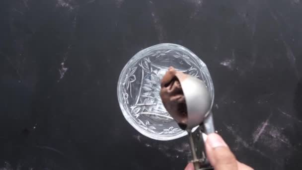 Hand het plukken van ijs met een lepel uit een kom — Stockvideo