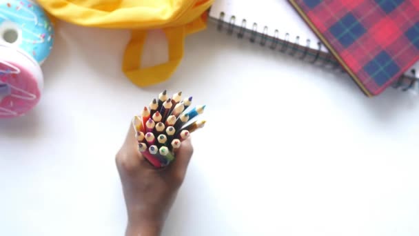 Девочка держит много цветных карандашей — стоковое видео