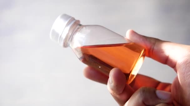Een fles met vloeibaar geneesmiddel op wit houden , — Stockvideo