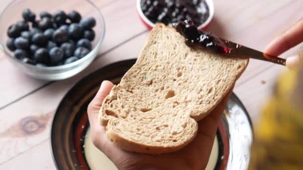 Blauwe bessenjam op brood op tafel, — Stockvideo