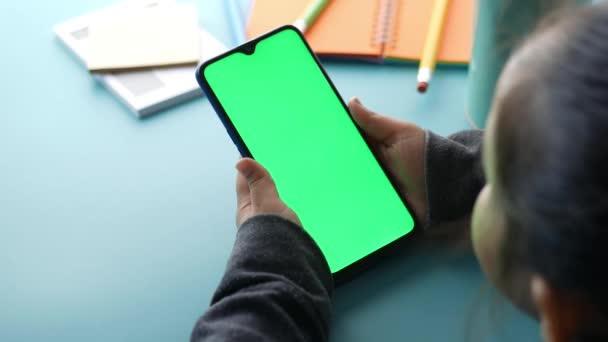 Rear view of child hand holding smart phone with green screen — Stock Video