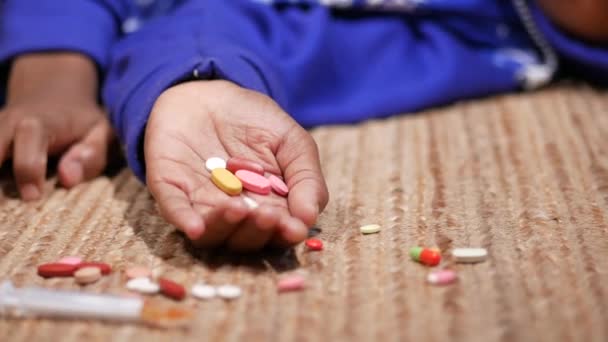 Concepto de adicción a las drogas con píldoras de mano y jeringa tendida en el suelo — Vídeos de Stock