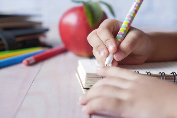 Kinderhand schrijven op notitieblok — Stockfoto