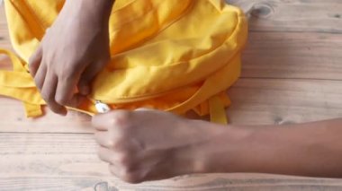 Çocuk okul çantasının fermuarını çekti. 