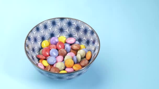 Barn pojke plocka flerfärgade söta godis i en skål på nära håll — Stockvideo
