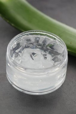 Taze aloe vera dilimlenmiş ve plastik kapta sıvı jel beyaz arka planda 