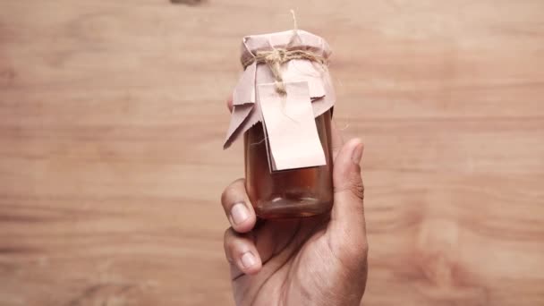 Fresh honey in a glass jar with a paper empty label — Stock Video