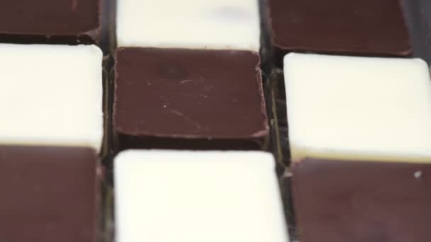 Dunkle und weiße Schokolade in einer Schachtel auf grauem Hintergrund — Stockvideo