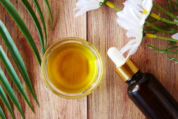 Эфирные масла эвкалипта в стеклянной бутылке и цветке на столе — стоковое фото