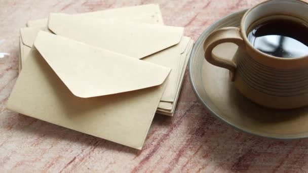 Pile d'enveloppe, fleur et tasse de thé sur la table — Video