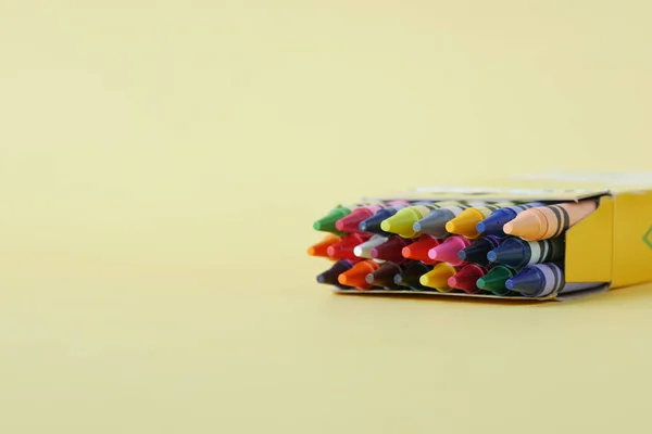 Color pencils on yellow papers on table — Stock Photo, Image