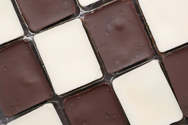Dark and white chocolate in a box on gray background — Stock Photo, Image
