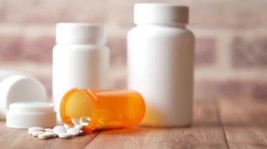  Masaya beyaz renkli tıbbi haplar dökülüyor. 