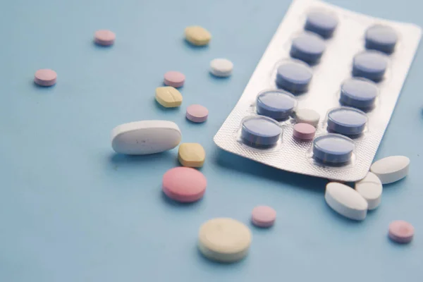 Närbild av piller av blisterförpackning och mediala piller på blå bakgrund — Stockfoto