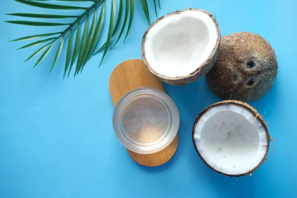 Vista superior de fatia de coco fresco e garrafa de óleo em uma mesa — Fotografia de Stock