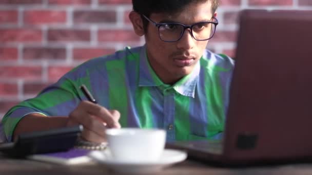 Молодой азиат работает на ноутбуке с копировальным пространством — стоковое видео