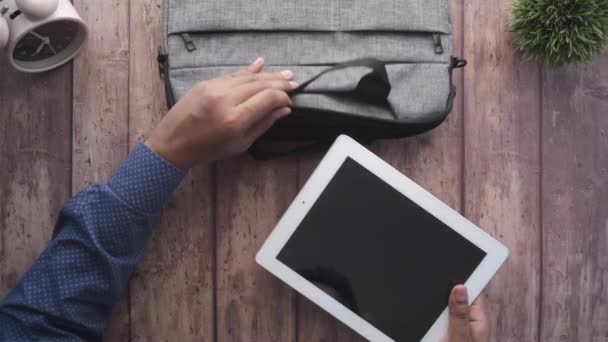 Pohled shora na mladého muže, jak si dává kancelář do tašky — Stock video