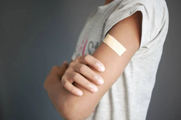 Adhesive bandage on young mans arm — Stock Photo, Image