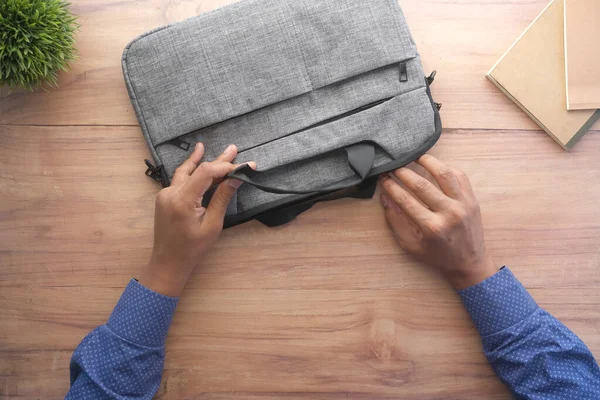 Hombre joven buscando algo en un bolso de hombro — Foto de Stock