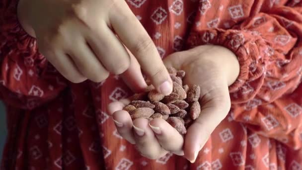 Mujeres jóvenes comiendo almendras frescas de cerca — Vídeos de Stock