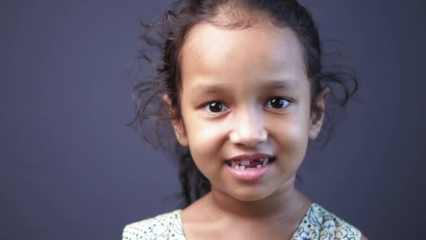 Gyermek lány portréja, ahogy a kamerába néz és nevet. — Stock videók