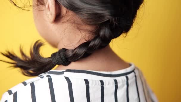 Bambino ragazza con i capelli lunghi contro sfondo giallo , — Video Stock