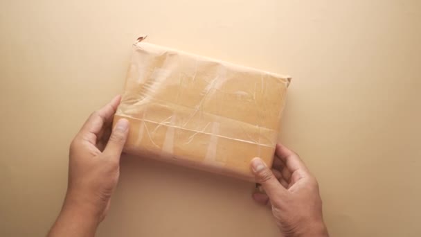 Bir teslimat zarfını masanın üstünde tutmanın en üst görüntüsü — Stok video