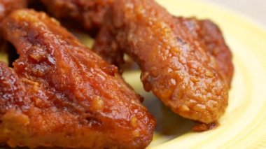 Plastik bir tabakta tavuk kanatları. Yakın plan. 