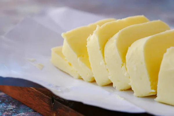 Gros plan de tranche de beurre sur une planche à découper — Photo