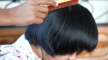 Çocuk saçlarını tarıyor. Yakından. 