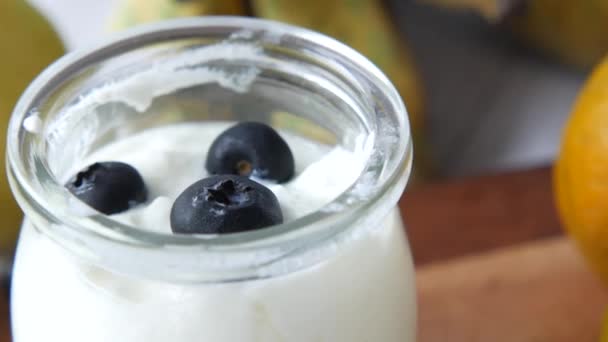 Primo piano di yogurt fresco con bacca azzurra in una boccia — Video Stock