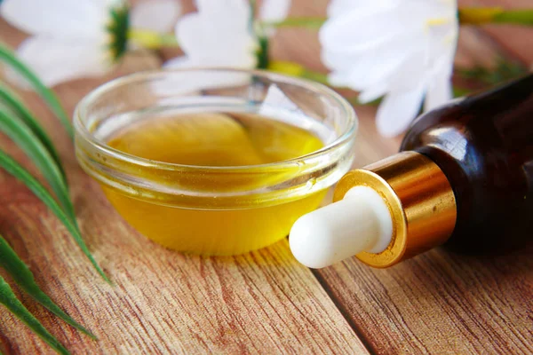 Pipette and oil in a small container on table — Stock Photo, Image