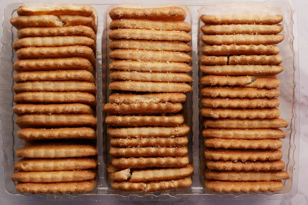 Perto de biscoitos de queijo em um empacotador na mesa — Fotografia de Stock