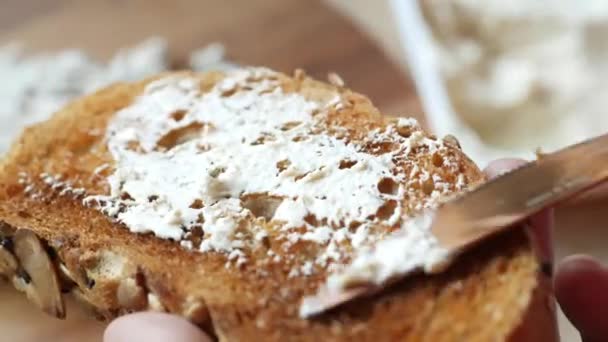 Χαμηλή γεγονός κρέμα τυριού εξάπλωση σε ένα ψωμί στο τραπέζι — Αρχείο Βίντεο