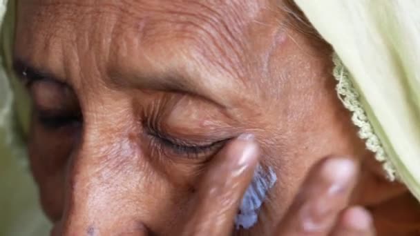 Donna anziana che applica la crema di bellezza sul viso — Video Stock