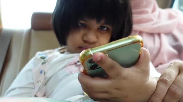 Child girl watching cartoon on smart phone while traveling — Stockvideo