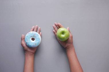 Mavi arka planda el ele tutuşma ve elma 