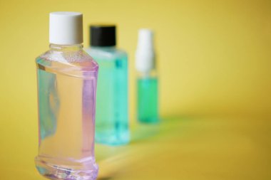 Sarı zemin üzerinde bir kapta ağız gargarası sıvısı 