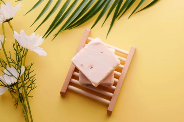 Homemade natural soap bar and flower on yellow background — Zdjęcie stockowe