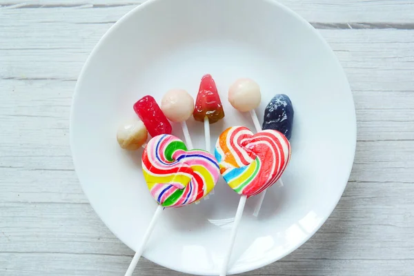 Top view of rainbow heart shape lollipop on plate — Stockfoto