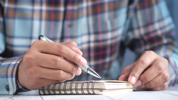 Om mână de scris pe notepad în timp ce așezat — Videoclip de stoc