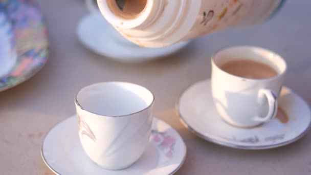 Налить чай в чашку на стол — стоковое видео
